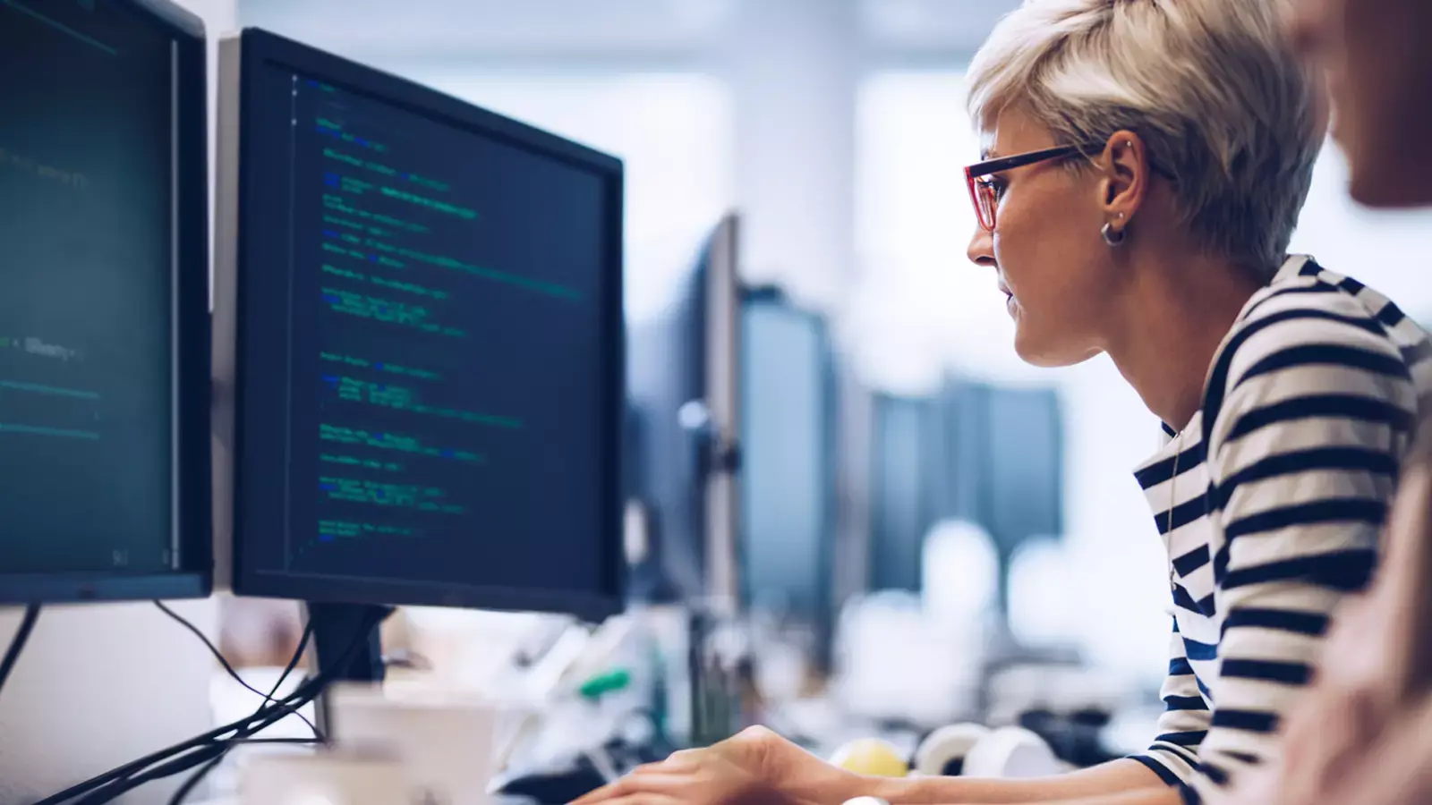 Software developer in front of two monitors